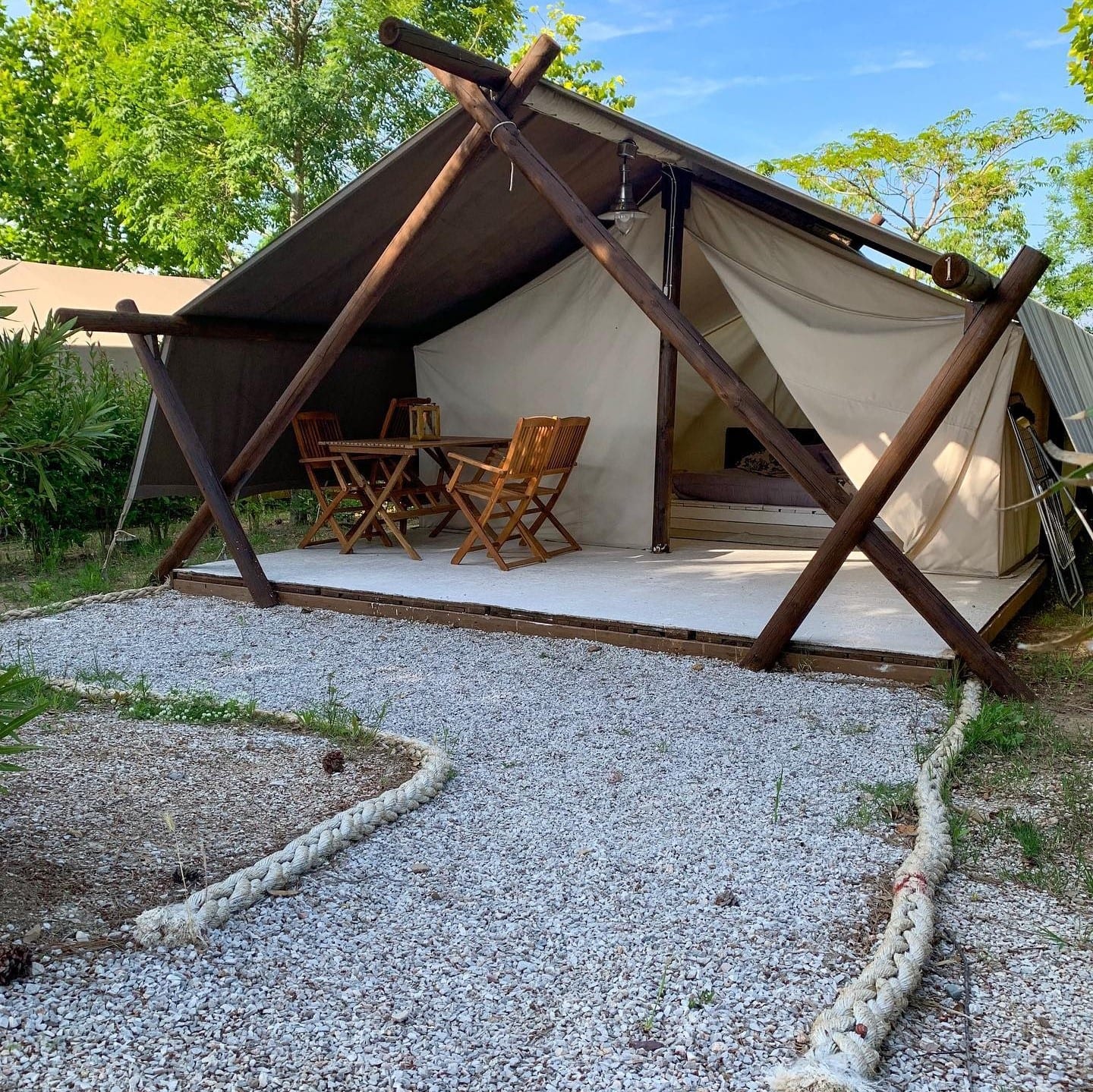 Tenda lodge con veranda in legno, ghiaia e corda